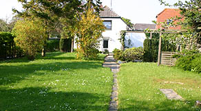 Sonnige Terrasse mit Strandkorb und Gartenmöbeln